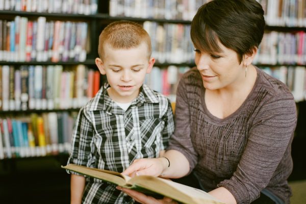 boy in gray sweater beside boy in gray and white plaid dress shirt