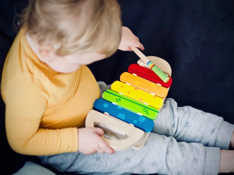 toddler playing wooden xylophone toy